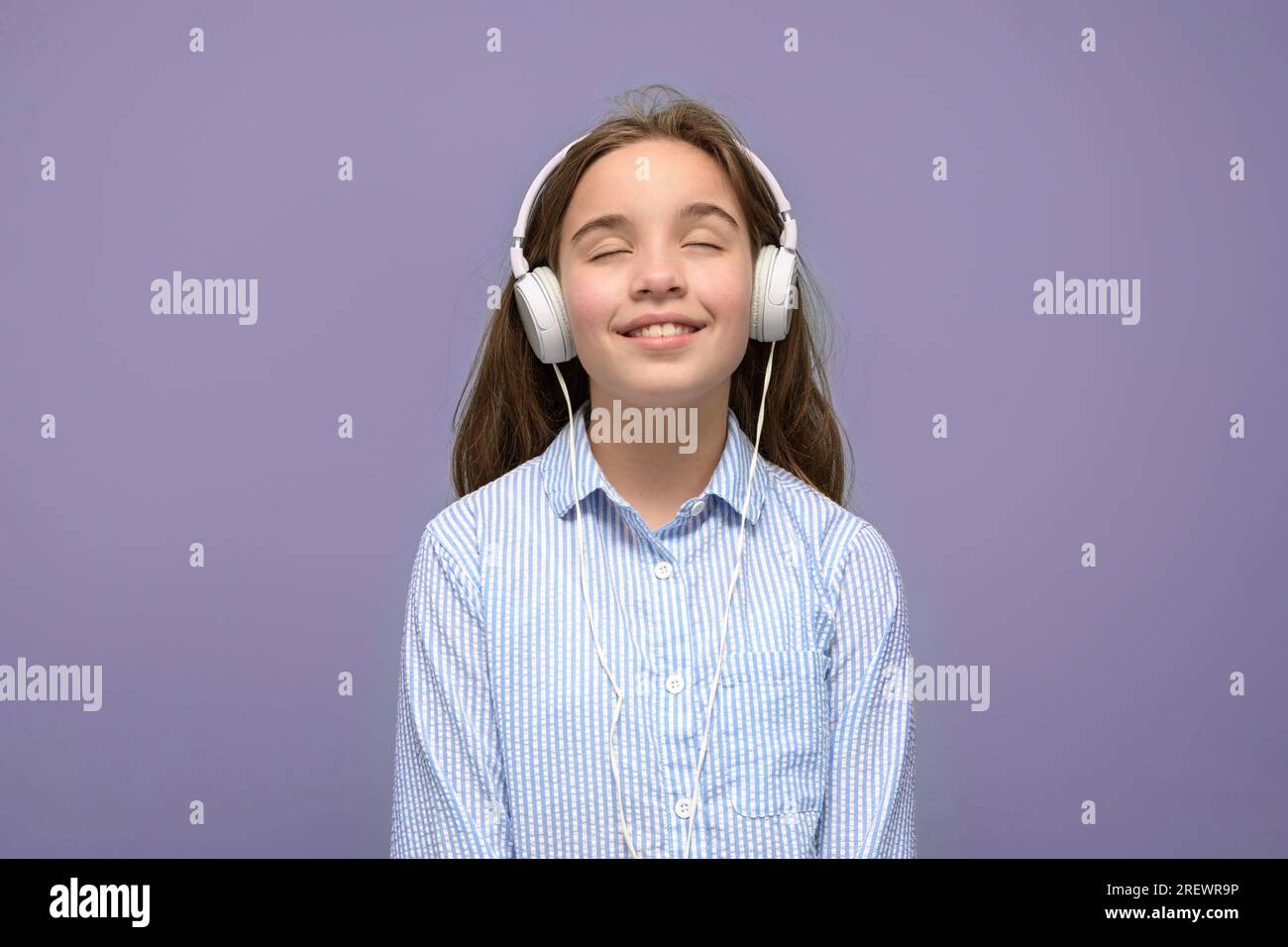 Teenager lieben Musik mit Kopfhörern. Rosafarbener Hintergrund Stockfoto