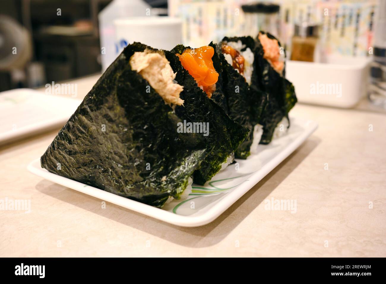 Juli 2023, japanische Reisbällchen (Onigiri) mit mehrfachem Belag und Füllungen, in Seetang (Nori) eingewickelt Stockfoto