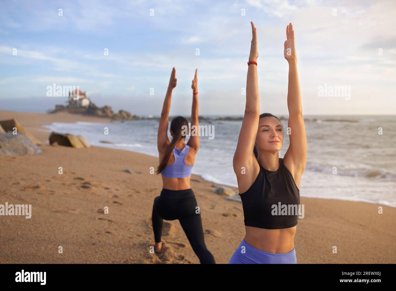 Positive, schlanke, weiße Jahrtausendschwestern Frauen üben Yoga, trainieren gern im Freien, Übungen für Hände, Pilates Stockfoto