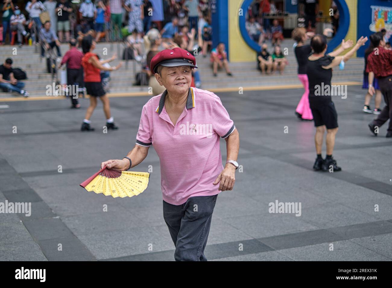 Eine ranghöchste Singapurerin, die sich fit hält, und eine improvisierte Tanzsitzung begleitet von chinesischer Musik; im Kreta Ayer Square, Chinatown, Singapur Stockfoto