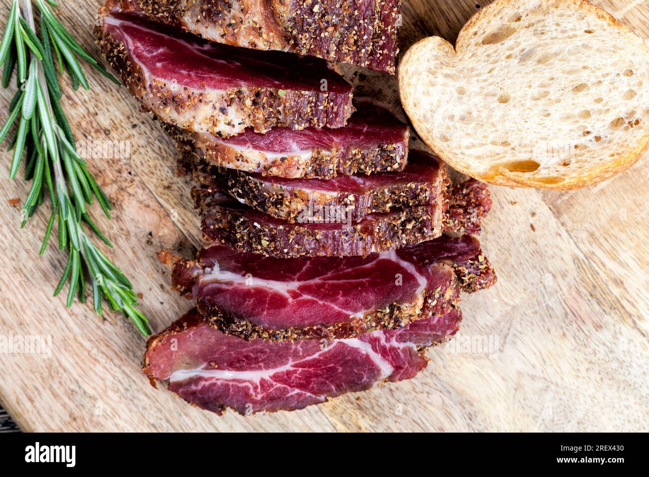 Fleisch zubereitetes mariniertes Rindfleisch, Schweinefleischprodukte mit Schmalz, auf dem Tisch mit Rosmarin geschnitten Stockfoto