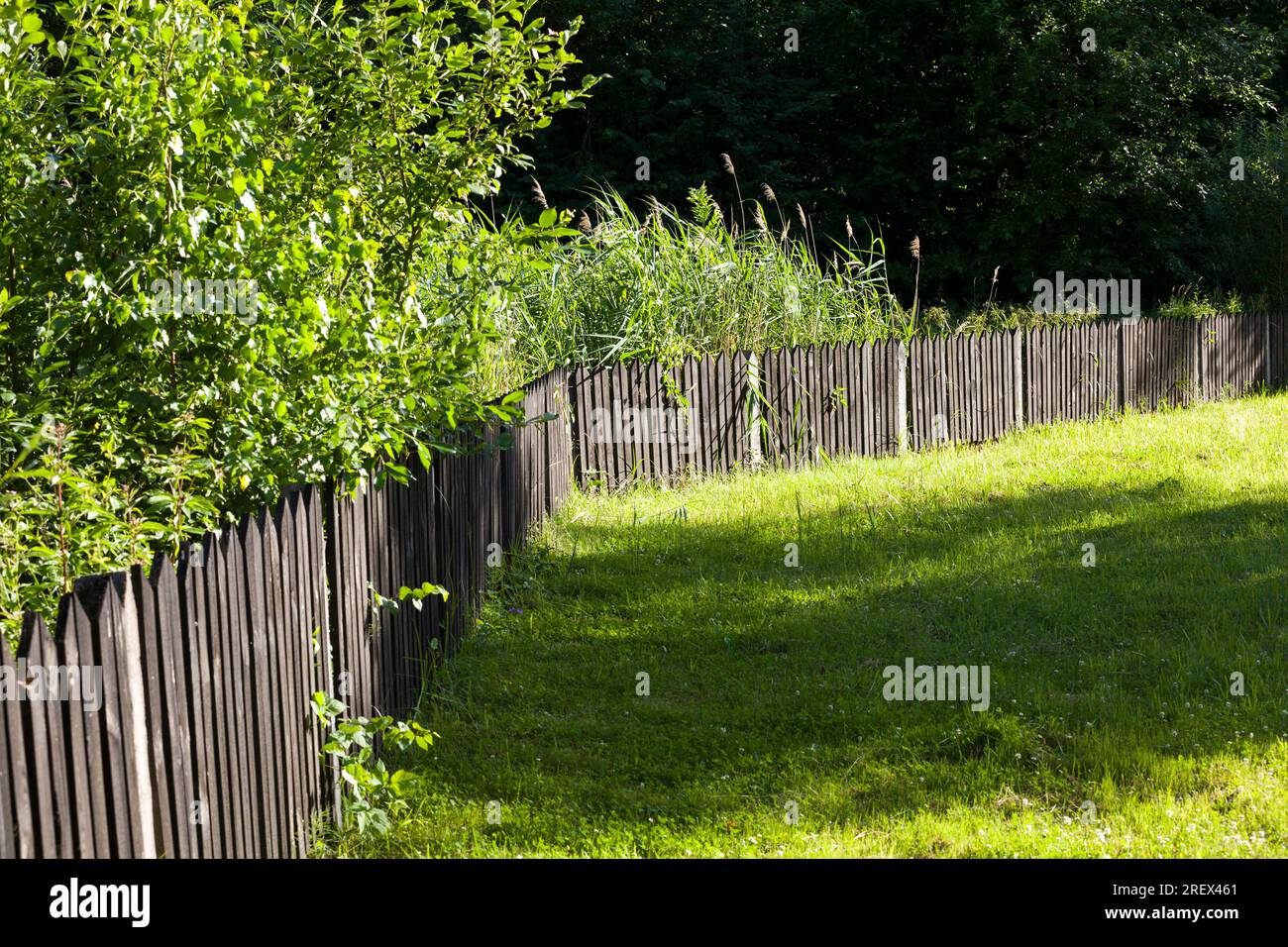 Detail des alten Holzzauns, der einen Bereich in einem ländlichen Bereich umschlossen, ein Zaun aus Holzzaun, der wenig Schutz bietet Stockfoto