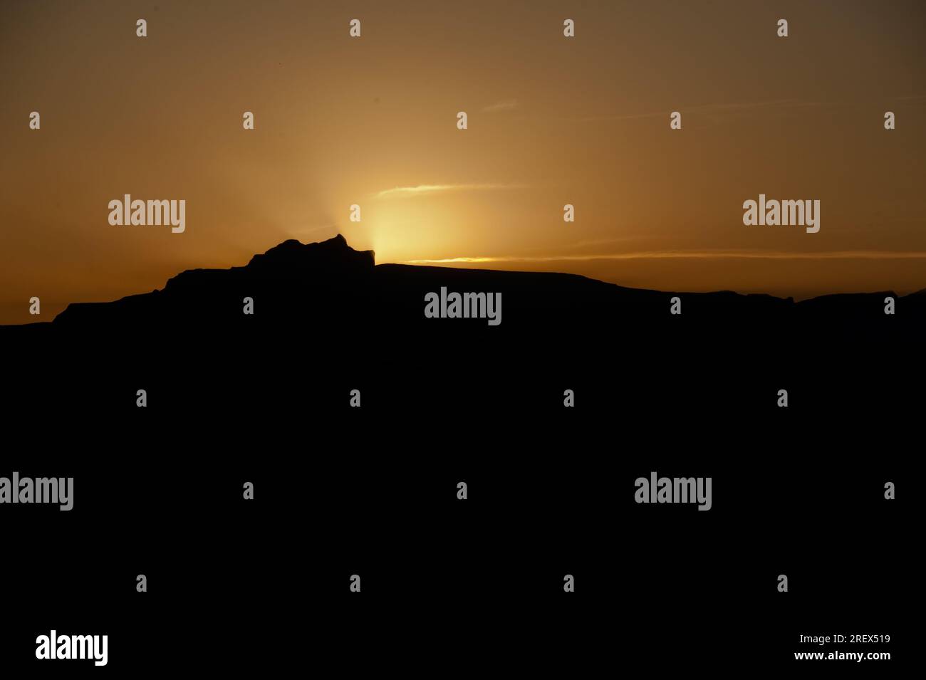 Silhouette eines Riesenschlosses mit Sonnenuntergang hinter dem Berg Stockfoto