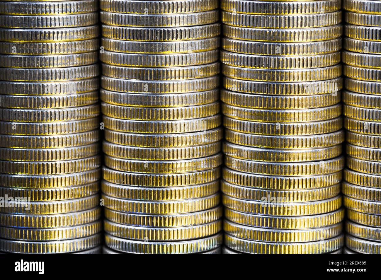 Viele runde Metallmünzen von silberner Farbe beleuchtet mit goldener Farbe, gesetzliches Zahlungsmittel, das für Zahlungen im Staat verwendet wird, schöne Münzen Nahaufnahme mit Stockfoto