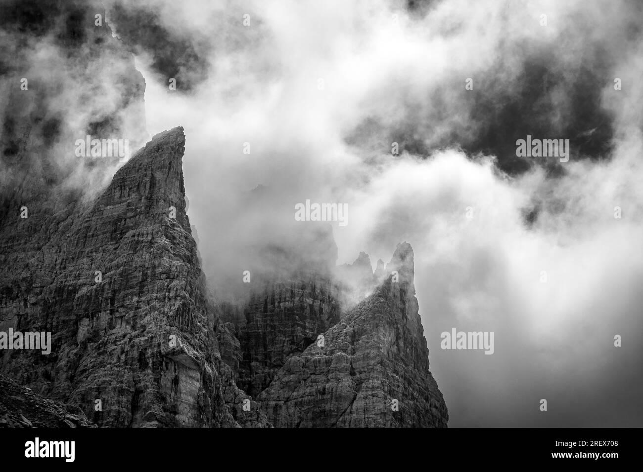 Profile von Berggipfeln. Sonnenlicht und dramatischer Himmel mit Wolken. Val Brenta alta. Trentino. Italienische Alpen. Europa. Stockfoto