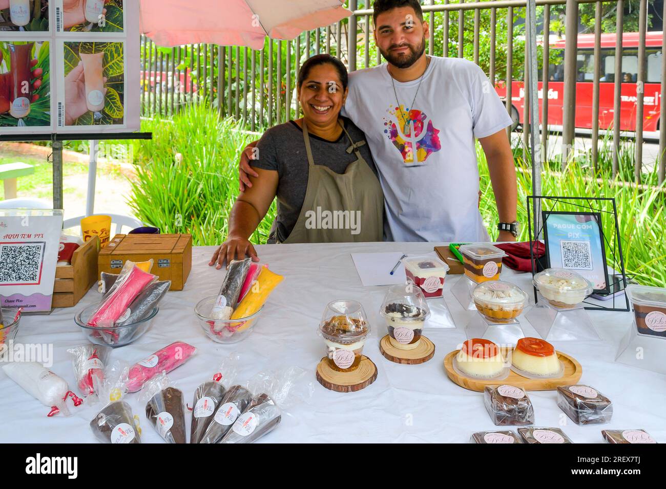 Niteroi, Brasilien, ein heterosexuelles Paar steht neben der Ware in einem Marktstand. Sie arbeiten zusammen an einem Kiosk, der hausgemachte Lebensmittel verkauft Stockfoto