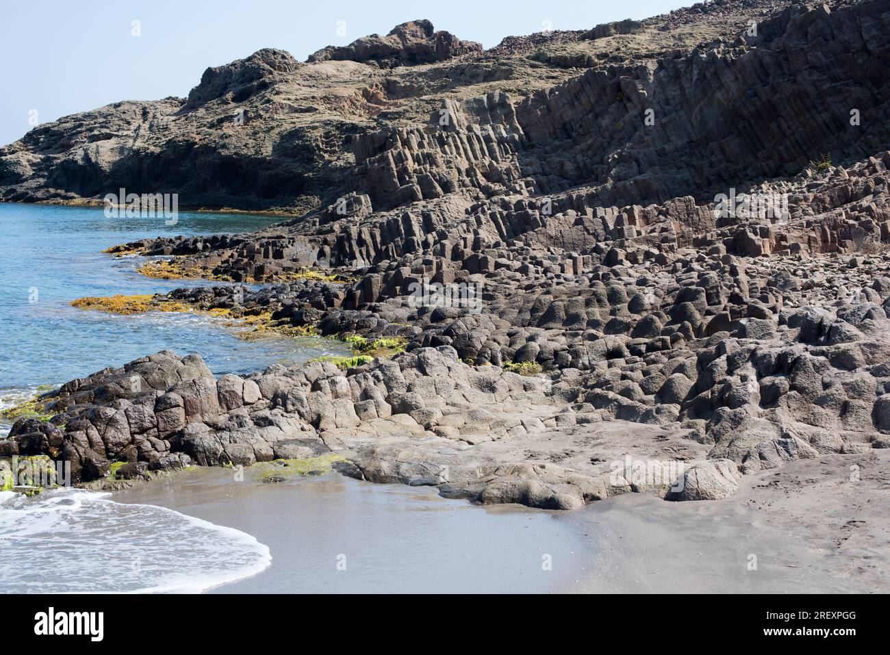 Säulenförmiger Dazit. Dacite ist ein extrusive oder vulkanisches Gestein. Dieses Foto wurde in Punta Baja, Cabo de Gata, Almeria, Andalusien, Spanien aufgenommen. Stockfoto