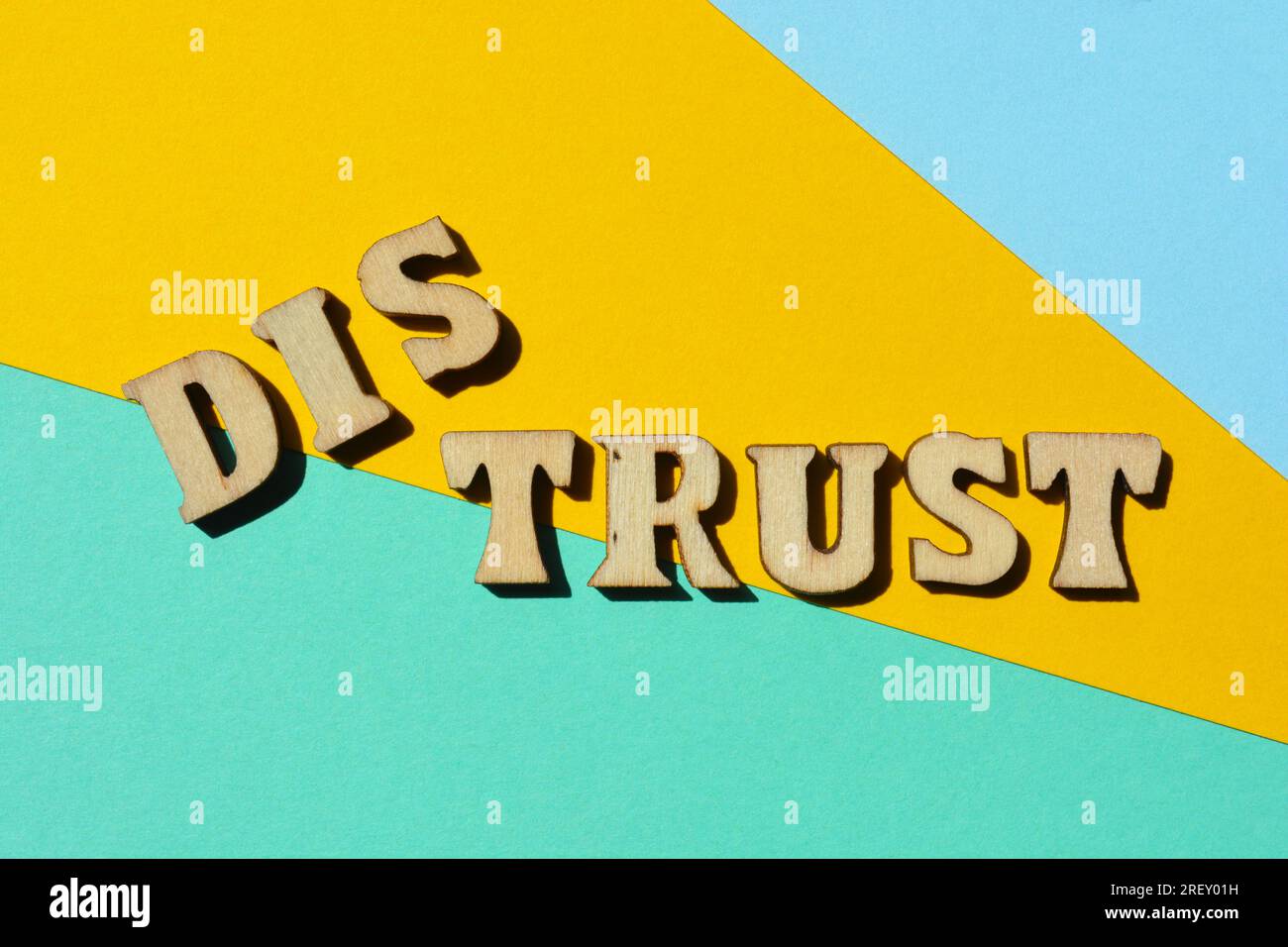 Vertrauen, Misstrauen, Wörter mit entgegengesetzter Bedeutung mit dem Präfix DIS in hölzernen Buchstaben isoliert auf dem Hintergrund Stockfoto