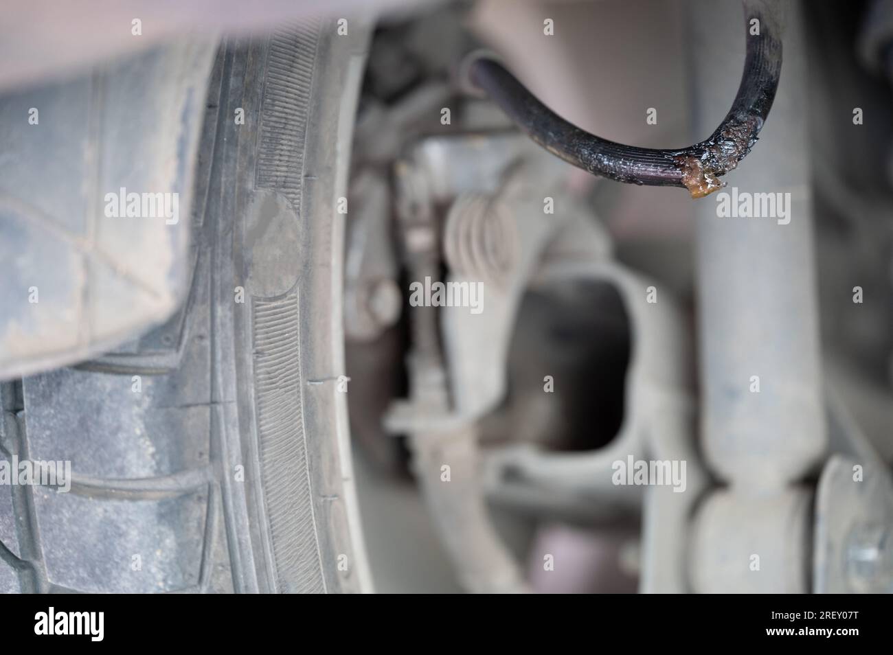 Bremsleitung im Auto bei unscharfem Hintergrund der Aufhängung austauschen Stockfoto