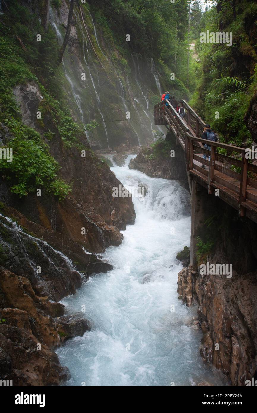 Touristen, die den Wimbachklamm-Wasserfall in der Ramsau-Schlucht, den Berchtesgaden-Nationalpark, Bayern, Deutschland, Europa besuchen Stockfoto