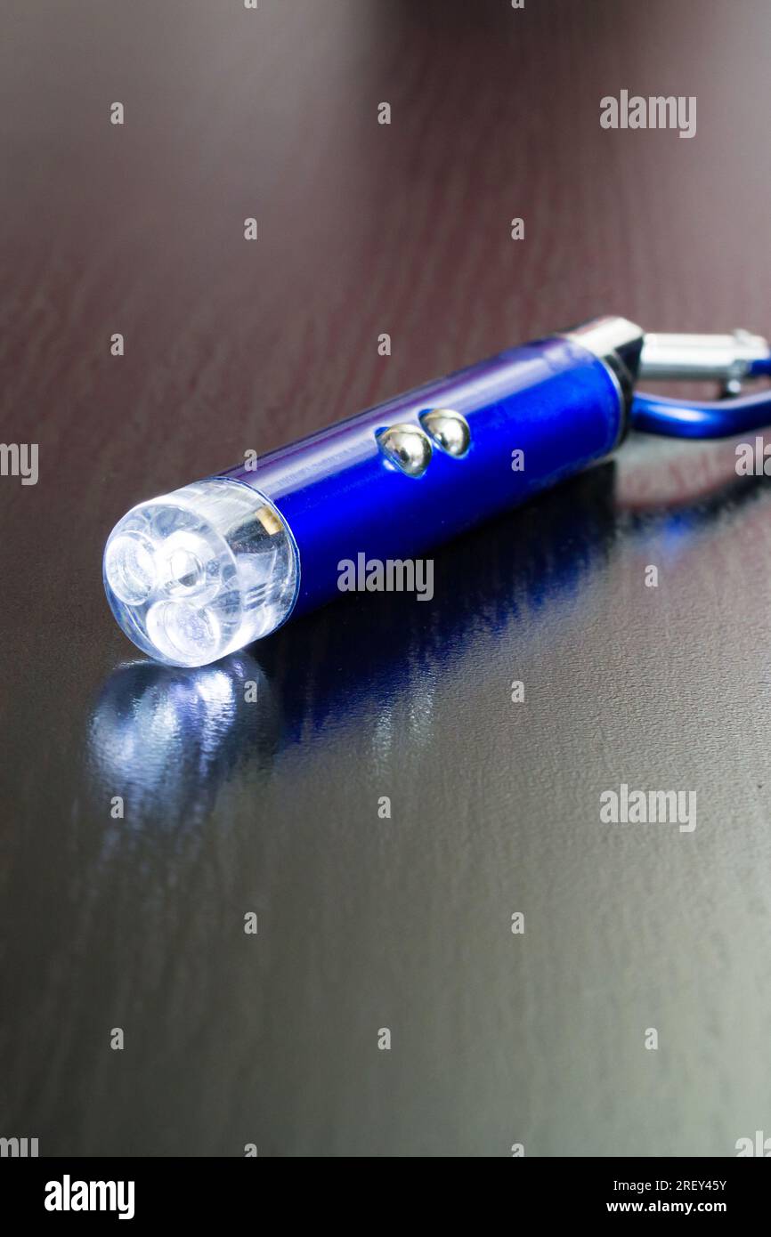 Blauer Laserpointer auf einem Holzhintergrund Stockfoto