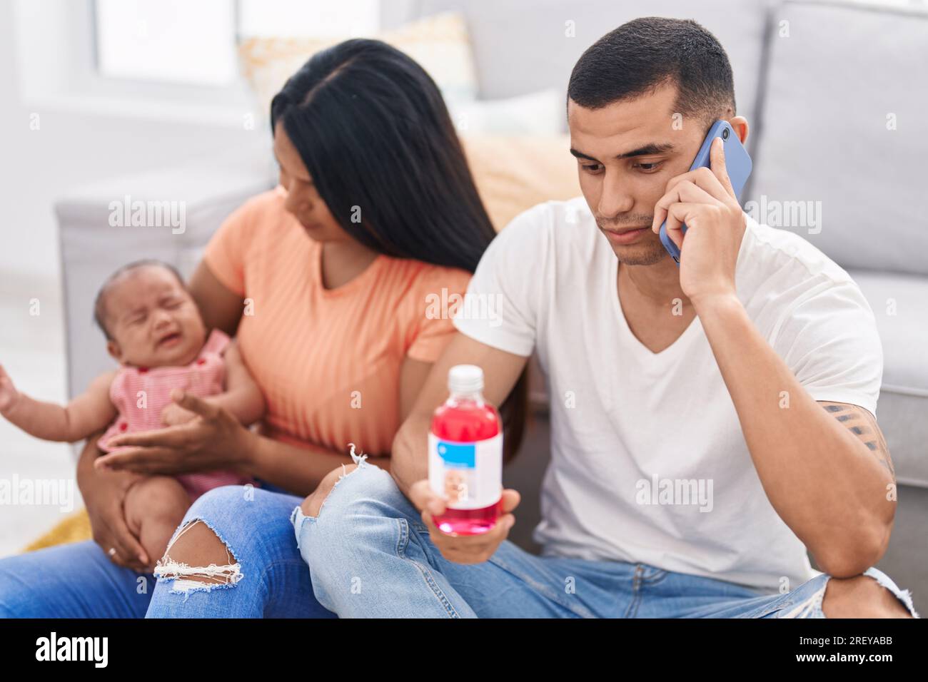 Hispanische Familie, die Telemedizin zu Hause auf dem Boden hat Stockfoto