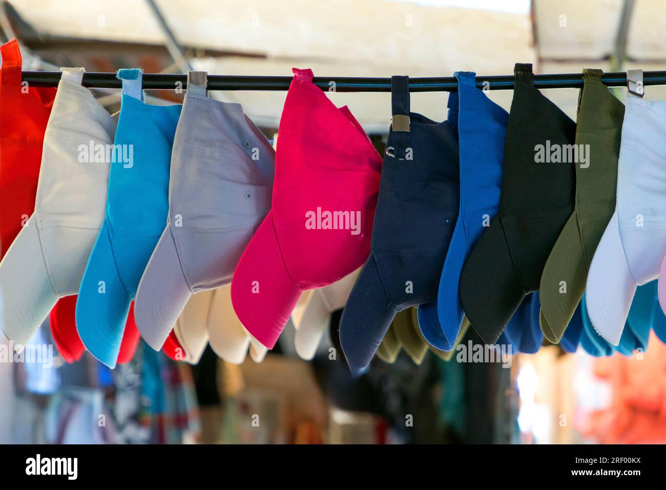 Farbenfrohe Sportkappen mit flachem Schirm, die im Freien auf einem Markt verkauft werden Stockfoto