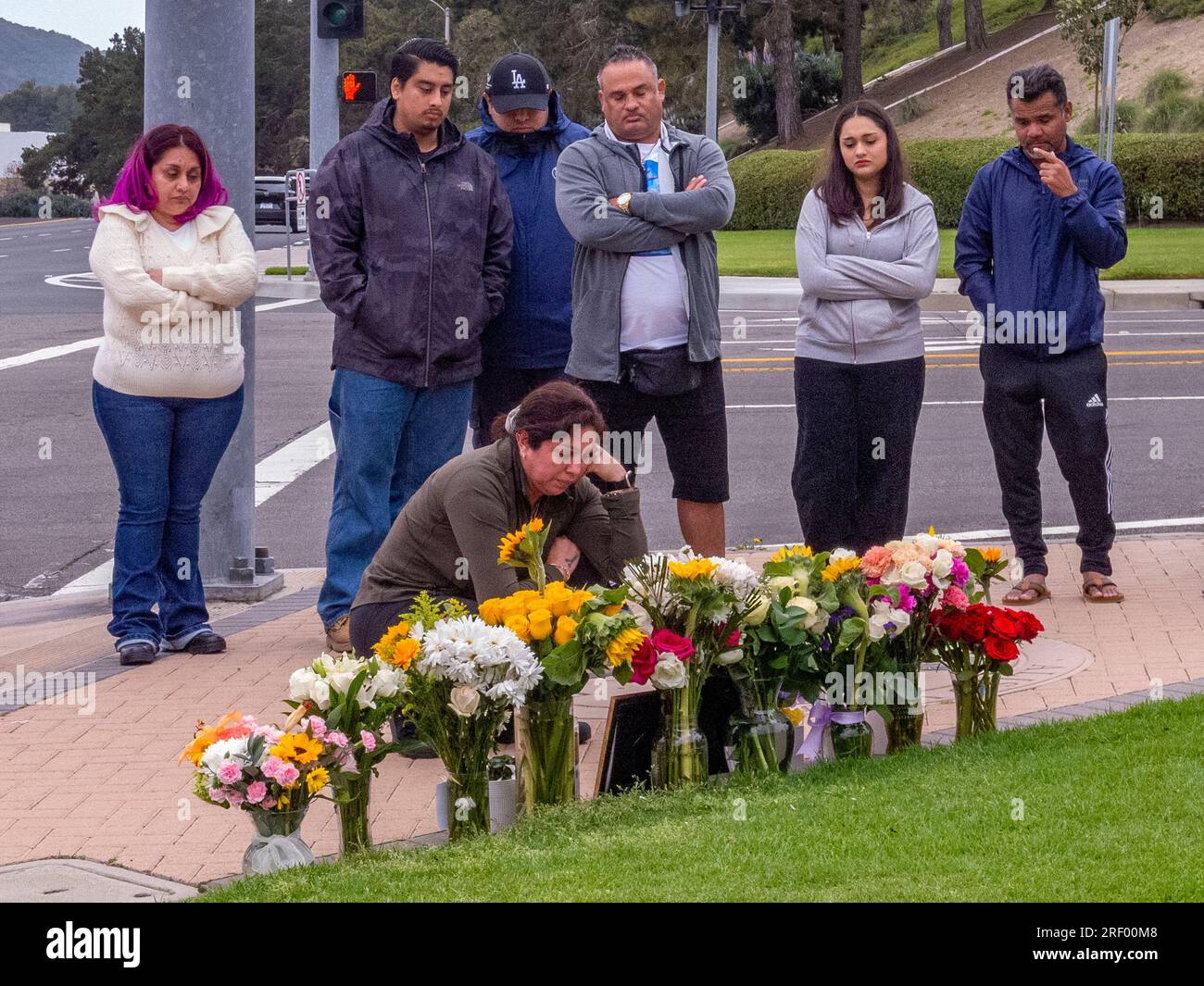 Multirassische Freunde und Angehörige eines Verkehrsunfallopfers versammeln sich zu einer informellen Gedenkfeier am Unfallort in Südkalifornien. Stockfoto