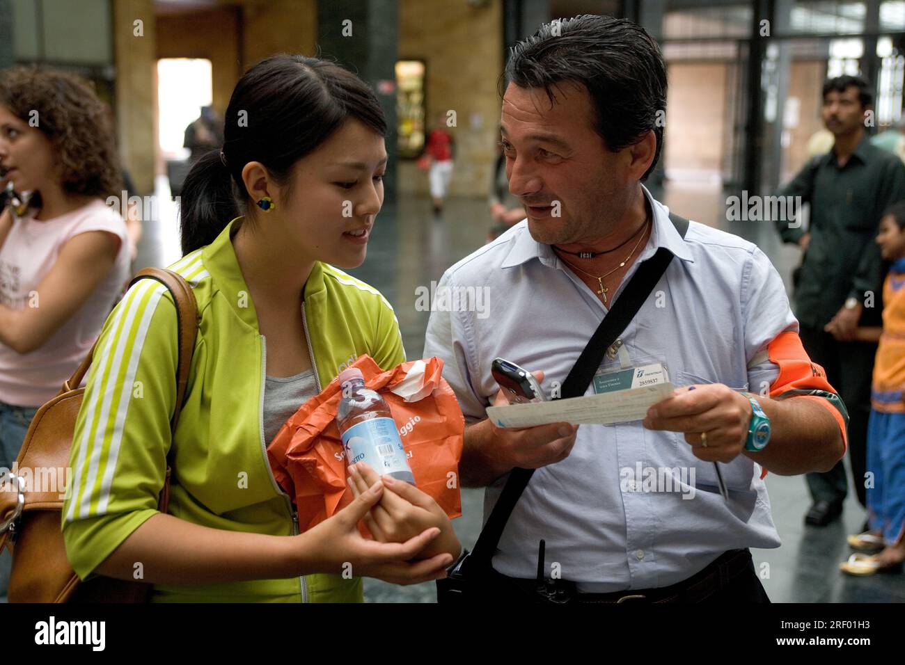 Mitarbeiter des Bahnhofs Trenitalia helfen den Fahrgästen am belebten Mailänder Hauptbahnhof, dem italienischen nationalen Eisenbahnsystem, 2005 Stockfoto