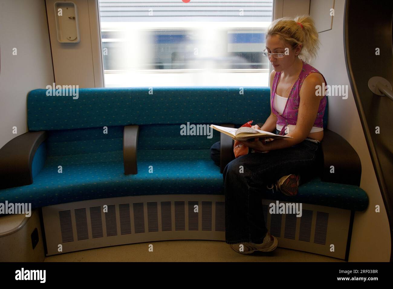 Eine Frau liest ein Buch, während sie im Zug in Amsterdam sitzt. Stockfoto