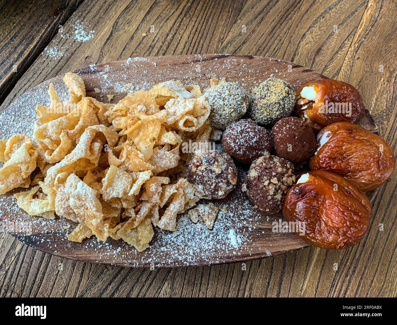Kasachstan, Almaty. Verschiedene Süßigkeiten zum Nachtisch: Gebratene Nudeln, Trüffel (Schokolade mit Pecan), Aprikosen gefüllt mit Mascarpone-Frischkäse Stockfoto
