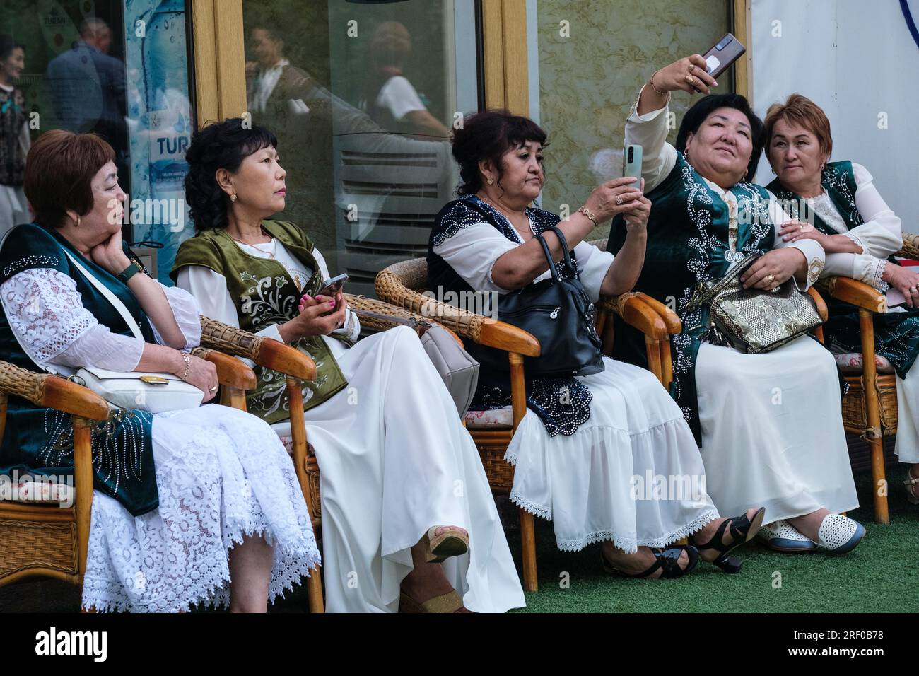 Kasachstan. Kasachische Frauen auf einem Schultreffen in traditionellem Kleid. Stockfoto