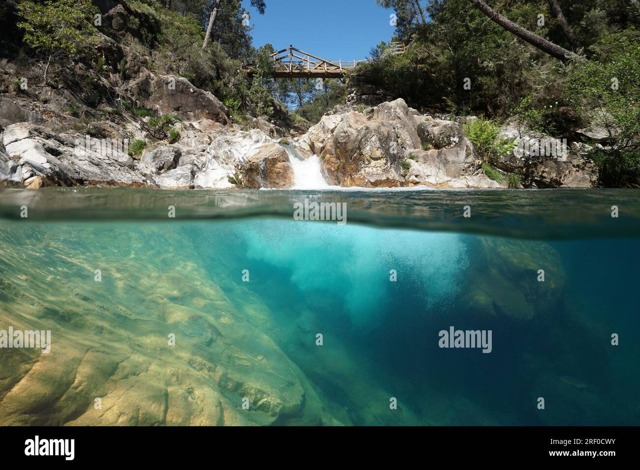 Natürlicher Pool in einem Fluss mit einer Kaskade, Naturszene, geteilter Blick über und unter der Wasseroberfläche, Spanien, Galicien, Provinz Pontevedra Stockfoto