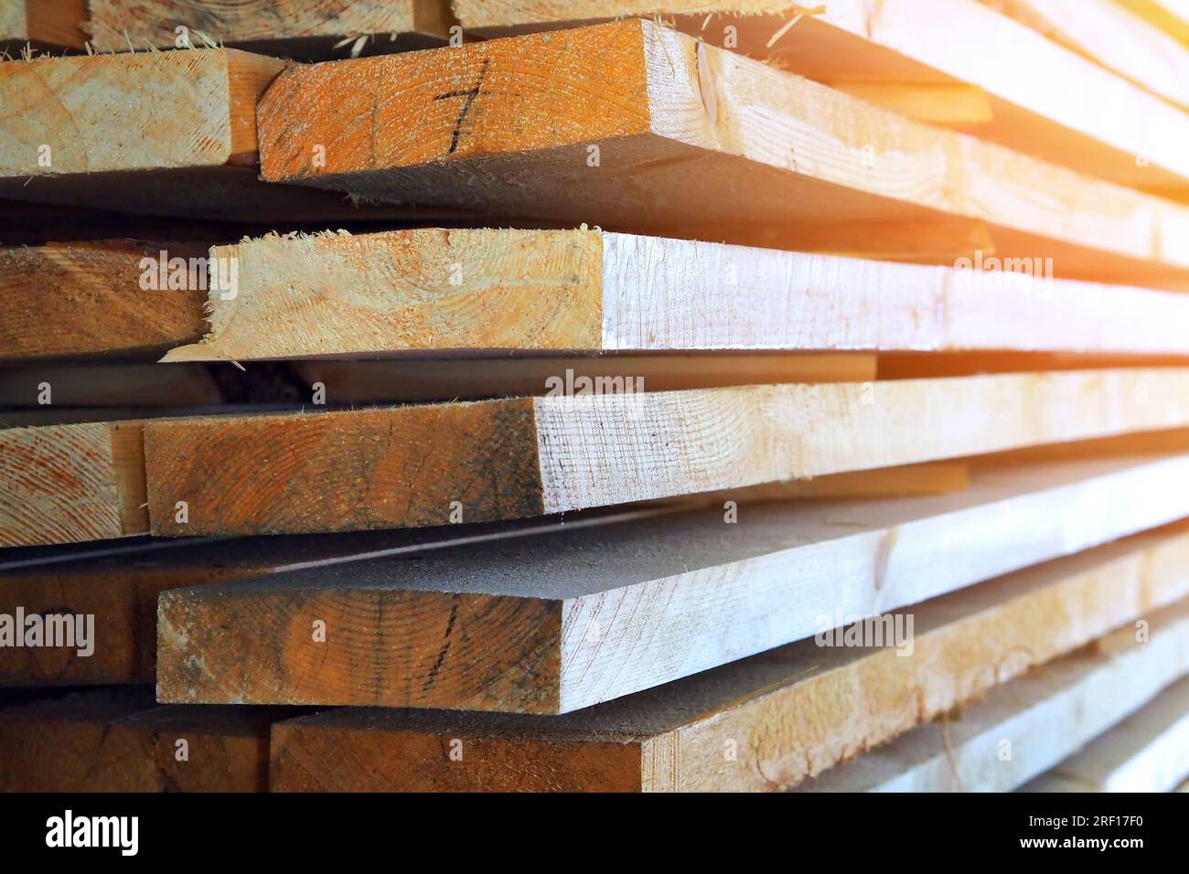 Neue gehobelte Holzbretter im Sägewerk gestapelt. Beschaffung und Verkauf von Baumaterial. Trockenes Holz. Holzbearbeitung. Hintergrund. Stockfoto