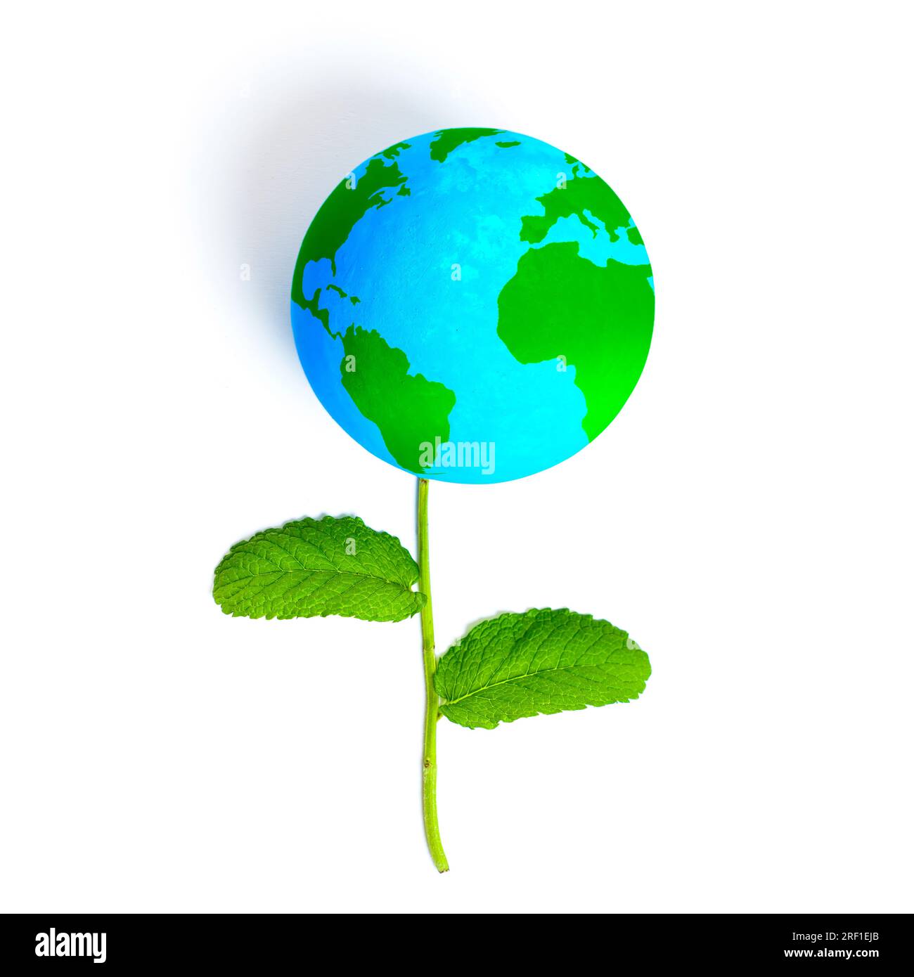 Blumenzusammensetzung mit einem blauen Globus mit leuchtend grünen Kontinenten anstelle der traditionellen Blüte. Zum Begriff des Umweltbewusstseins A Stockfoto