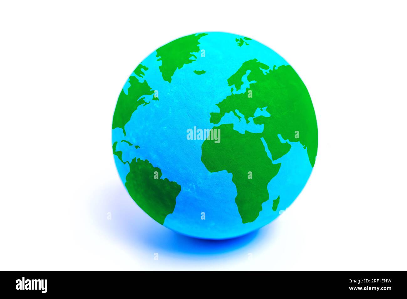 Globe-Modell mit leuchtend grünen Kontinenten und blauen Ozeanen isoliert auf einem sauberen weißen Hintergrund. Umweltbewusstsein und weltweiter Einheitskonflikt Stockfoto