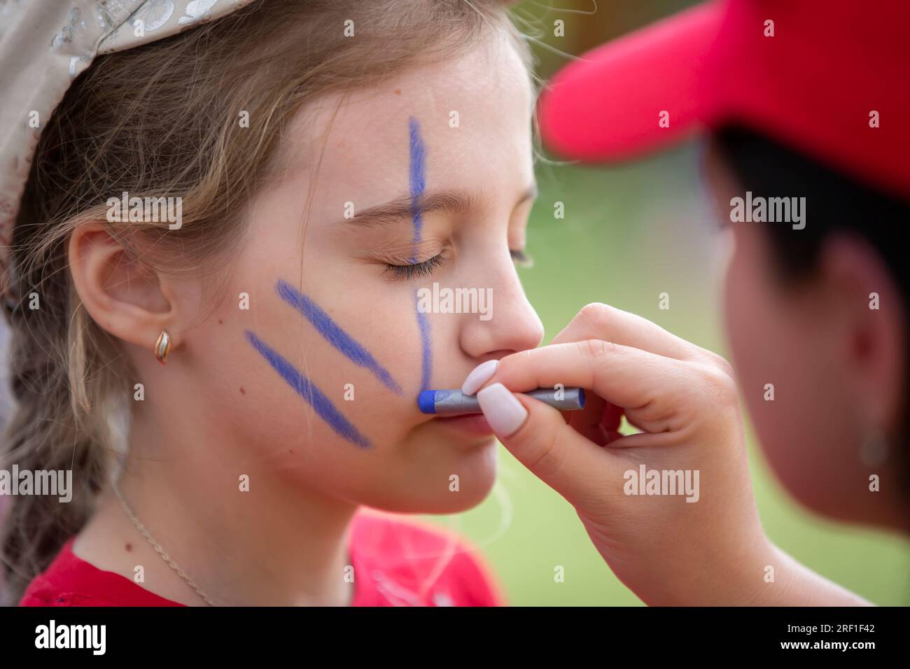 27. Mai, 2021. Belarus. Dorf Yagodnaya. Kinderurlaub. Make-up-Künstler zeichnet Gesichtsmalerei auf das Gesicht eines Kindes. Stockfoto