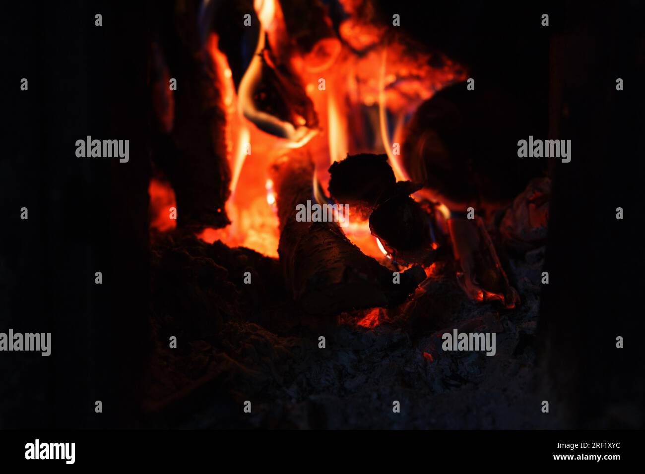 Ein helles Feuer mit hoher Temperatur aus natürlichem Brennholz und Ästen brennt im Ofen und heizt das Haus in der kalten Jahreszeit, mit Schönheitshorizont Stockfoto