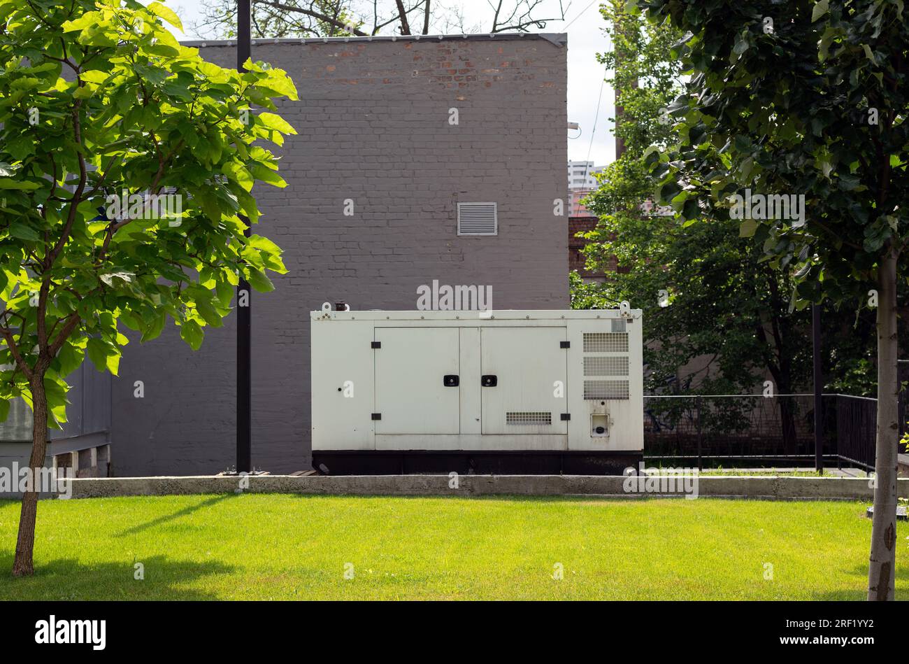 Zusätzlicher Dieselgenerator für die Notstromversorgung. Industrieller Generator, der über einen Kabeldraht mit der Zentrale verbunden ist. Notstromversorgung des Stockfoto