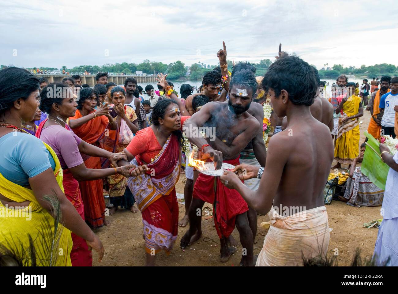 Ein Mann, der versucht, eine Frau zu kontrollieren, die von Gottes Macht beeinflusst wird, und das Vaikasi Visakam Festival in Tiruchendur, Tamil Nadu, Südindien anwendet Stockfoto