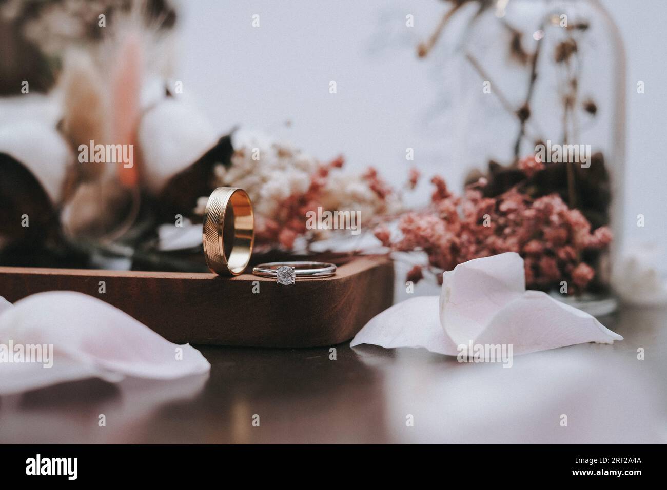 Ehering aus nächster Nähe mit verschwommenem Hintergrund und Blumen Stockfoto