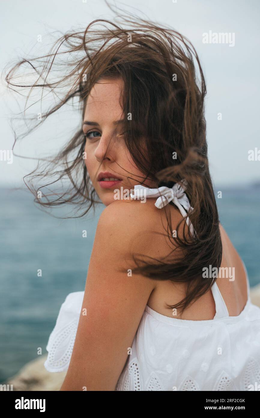 Nahaufnahme einer jungen Frau mit Wind im Haar Stockfoto