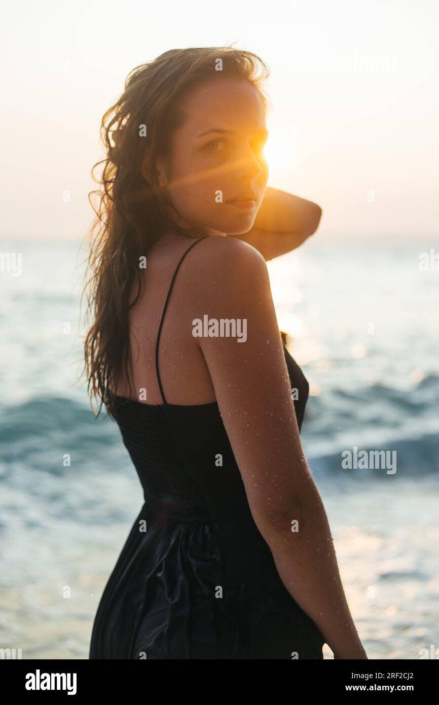Porträt einer jungen Frau mit Sonnenstrahlen im Gesicht Stockfoto
