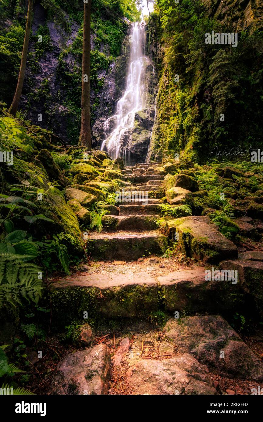 Der Burgbach-Wasserfall im Schwarzwald Deutschland. Aufgenommen im Sommer fällt er eine Klippe zwischen Bäumen hinunter Stockfoto