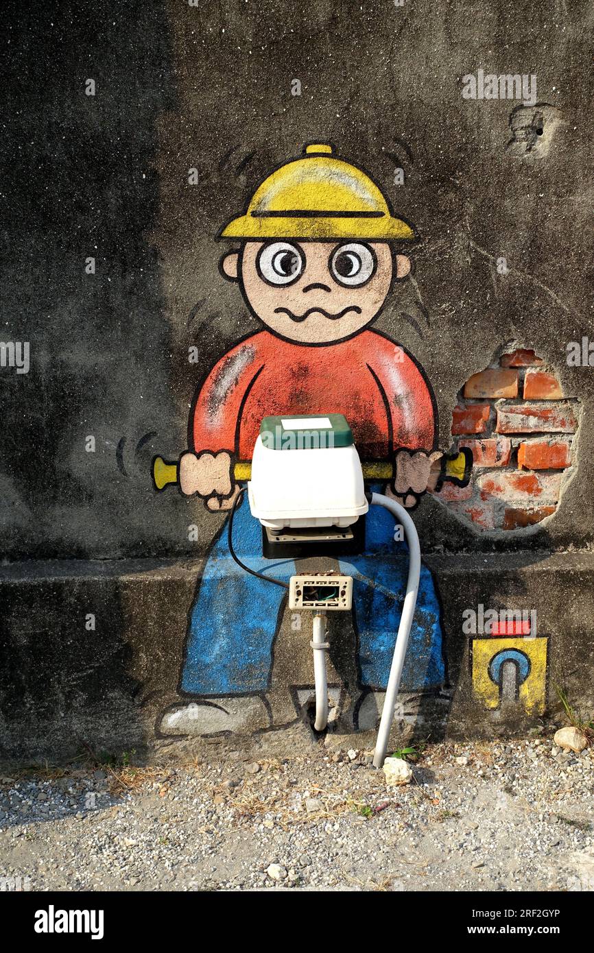Graffiti 'Bauarbeiter mit Presslufthammer' umgebaute Hausverbindung an einer Fassade, Taiwan, Kaohsiung Stockfoto