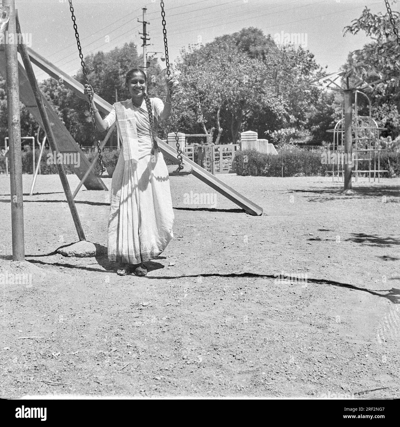 Altes, 1900er Jahre altes Schwarz-Weiß-Bild einer indischen Frau auf dem Schaukelspielplatz India 1940er Stockfoto