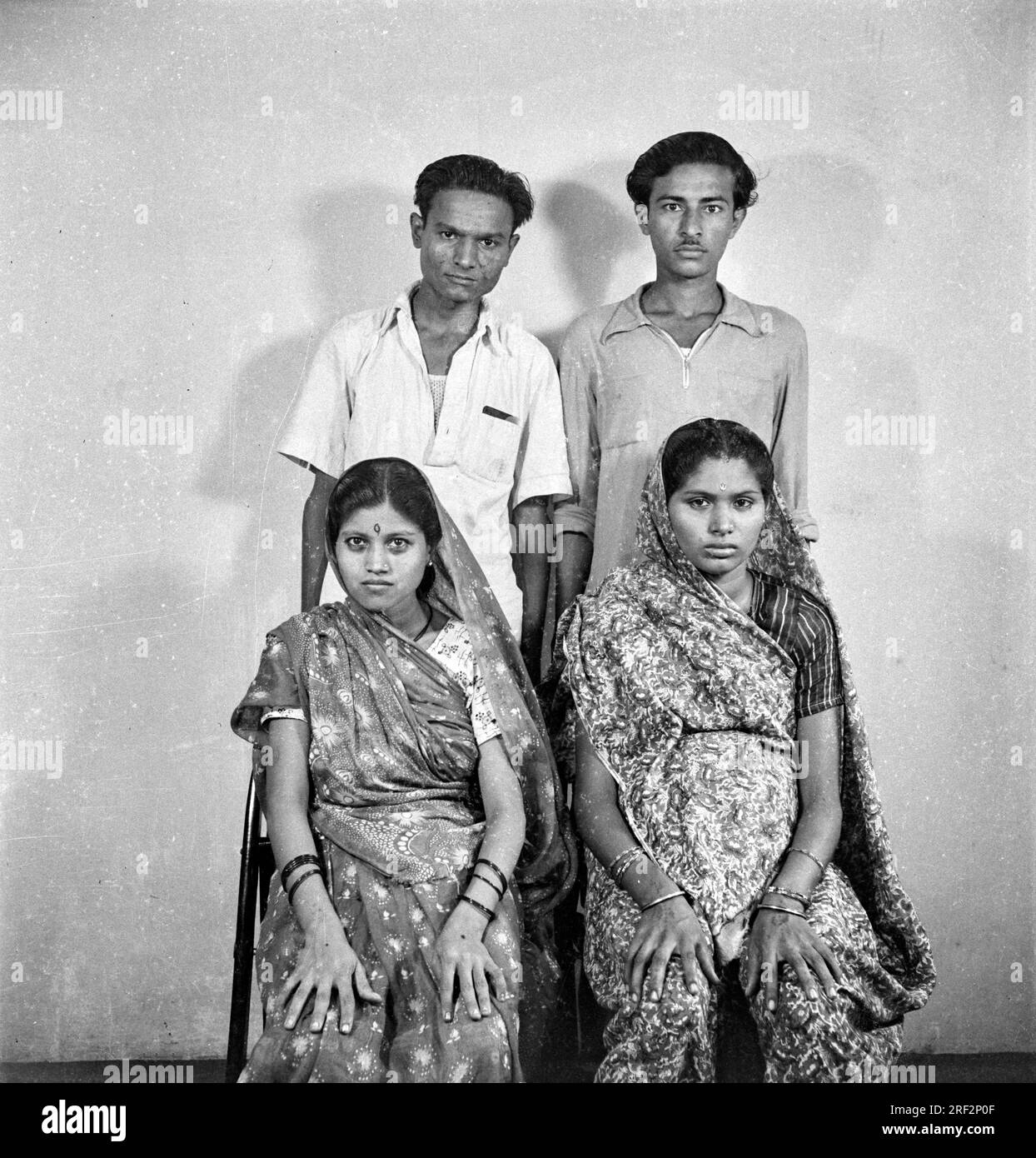 Altes, 1900er Jahre altes, schwarz-weißes Studioporträt der indischen Familie, zwei Brüder mit ihren Frauen Indien 1940er Stockfoto
