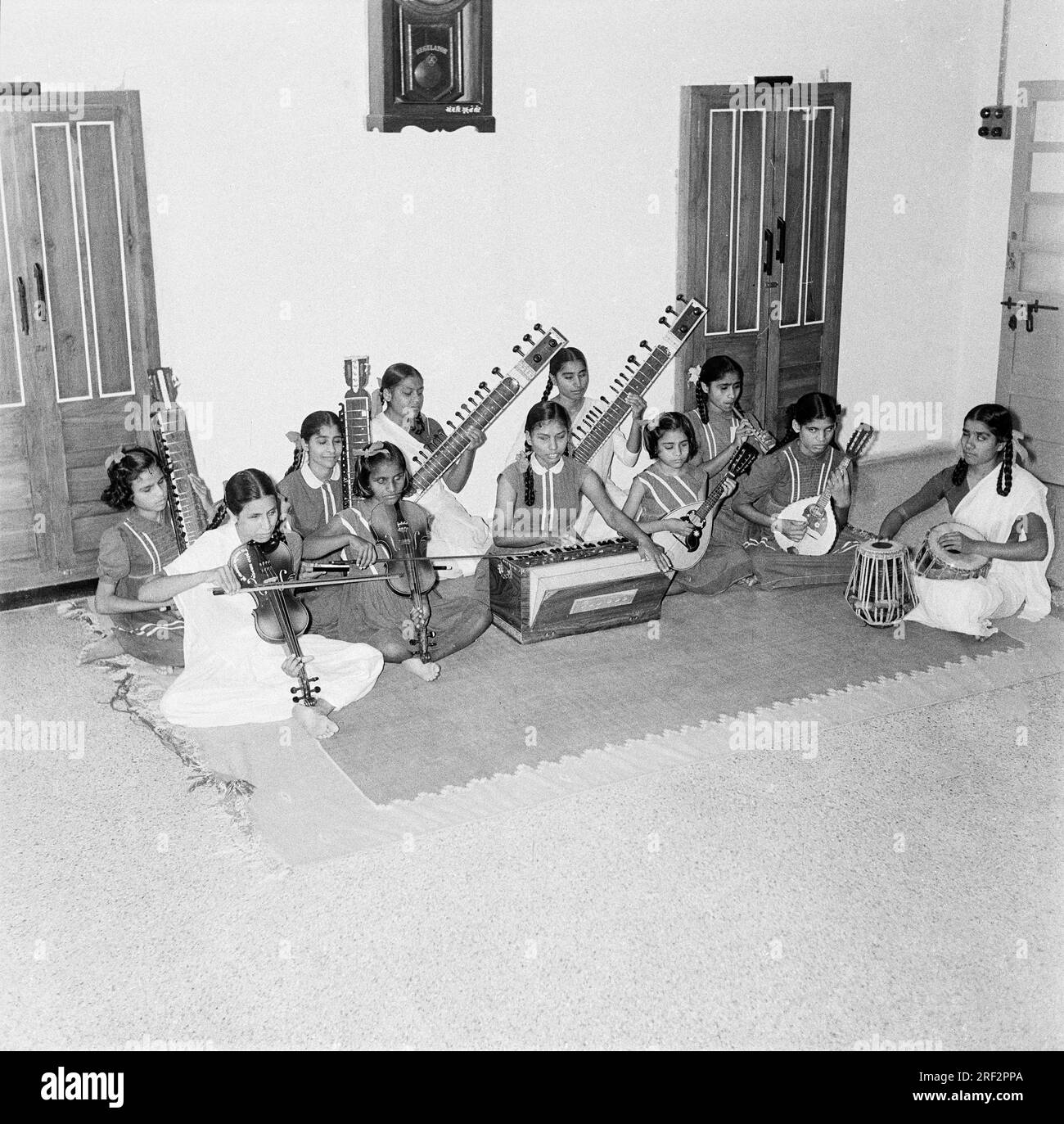 Altes schwarzweißes Bild aus dem Jahr 1900er von blinden Kindern, die Musikinstrumente spielen, Harmonium tabla Violine Sitar Indien Stockfoto