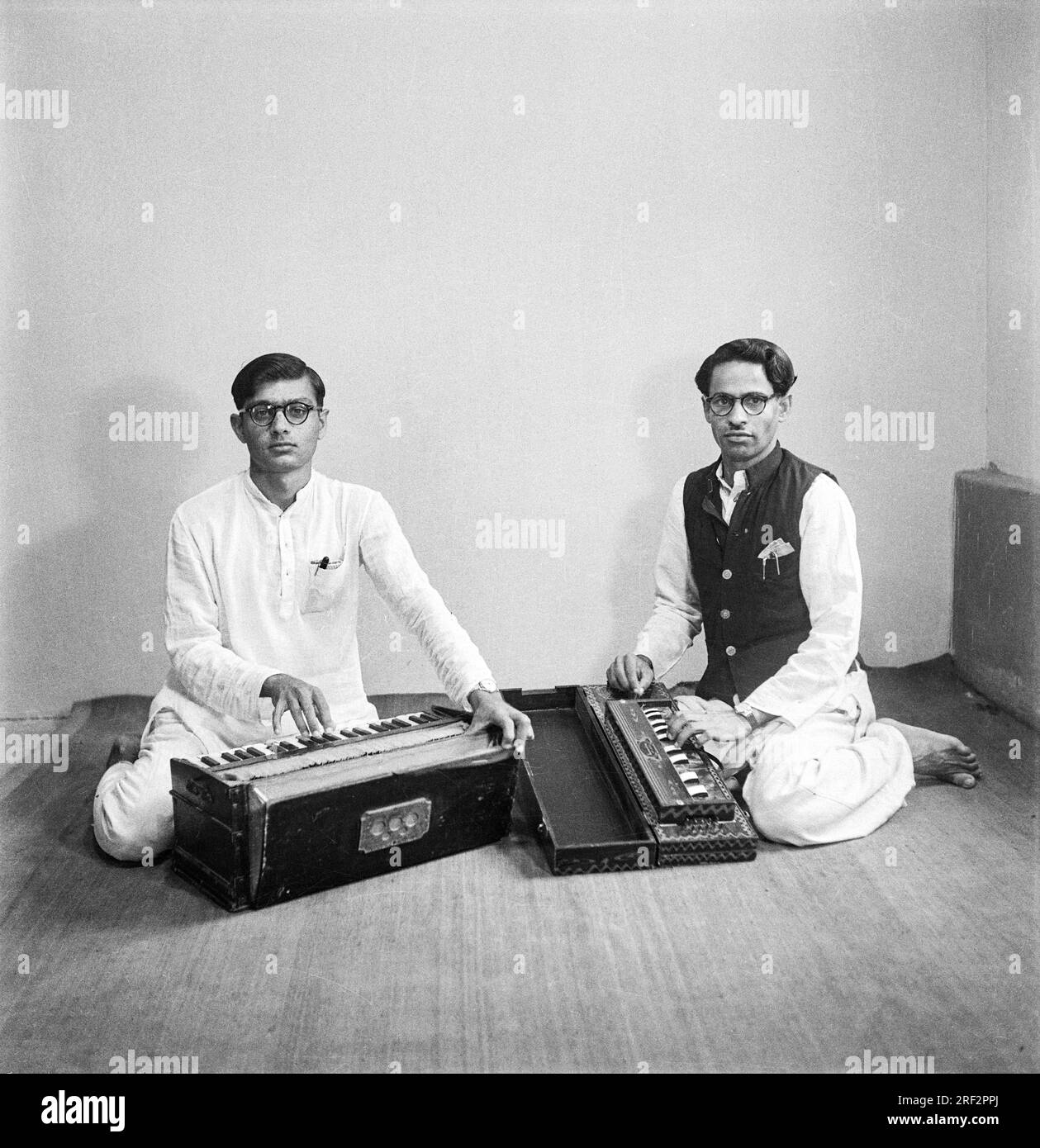 Ein altes 1900er Jahre altes Schwarz-Weiß-Studio Porträt Indianer zwei Männer spielen Musikinstrument Harmonium India Stockfoto