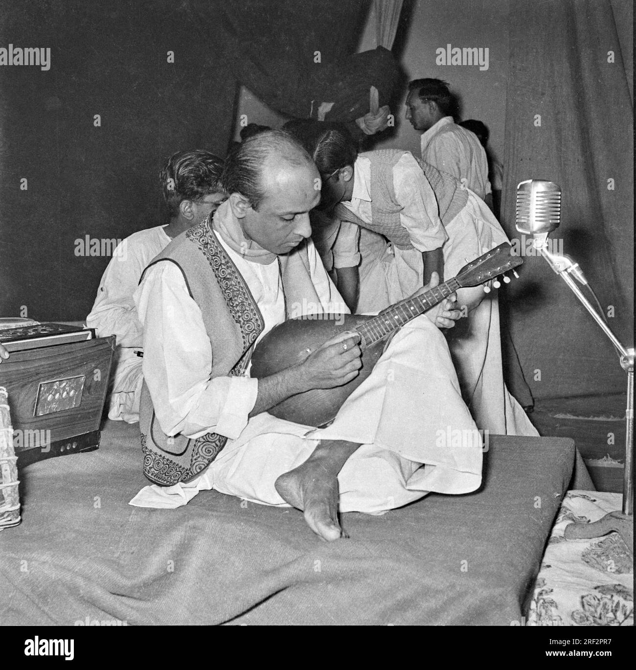 Altes schwarz-weißes 1900er-Bild eines indischen Musikers, der das Instrument Mandolin Streicher Indiens 1940er spielt Stockfoto
