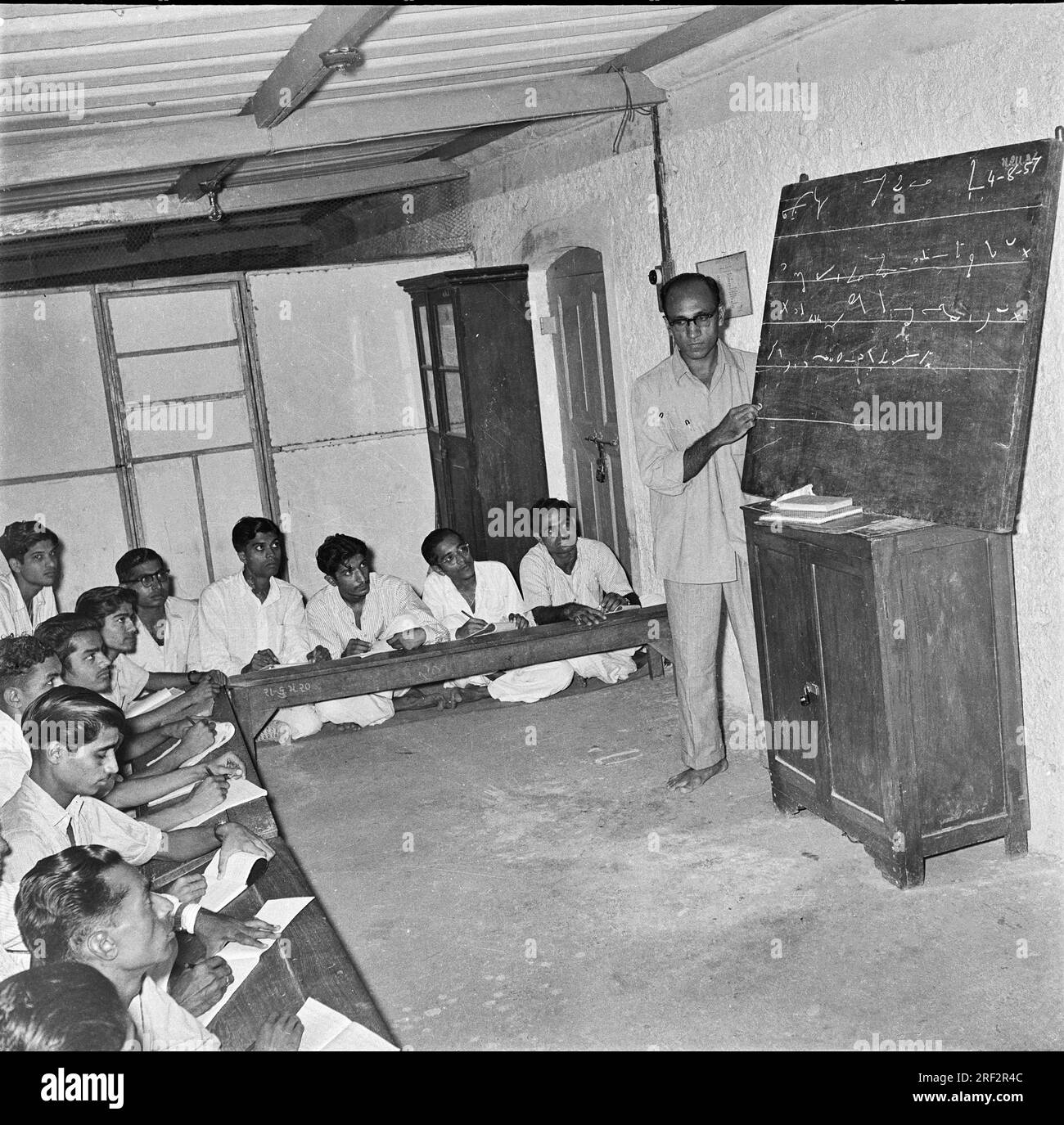 Altes, 1900er Jahre altes Schwarz-Weiß-Bild eines indischen Lehrers, der Männer in Kurzform lehrt, Rajkot Gujarat India, 4. August 1957 Stockfoto