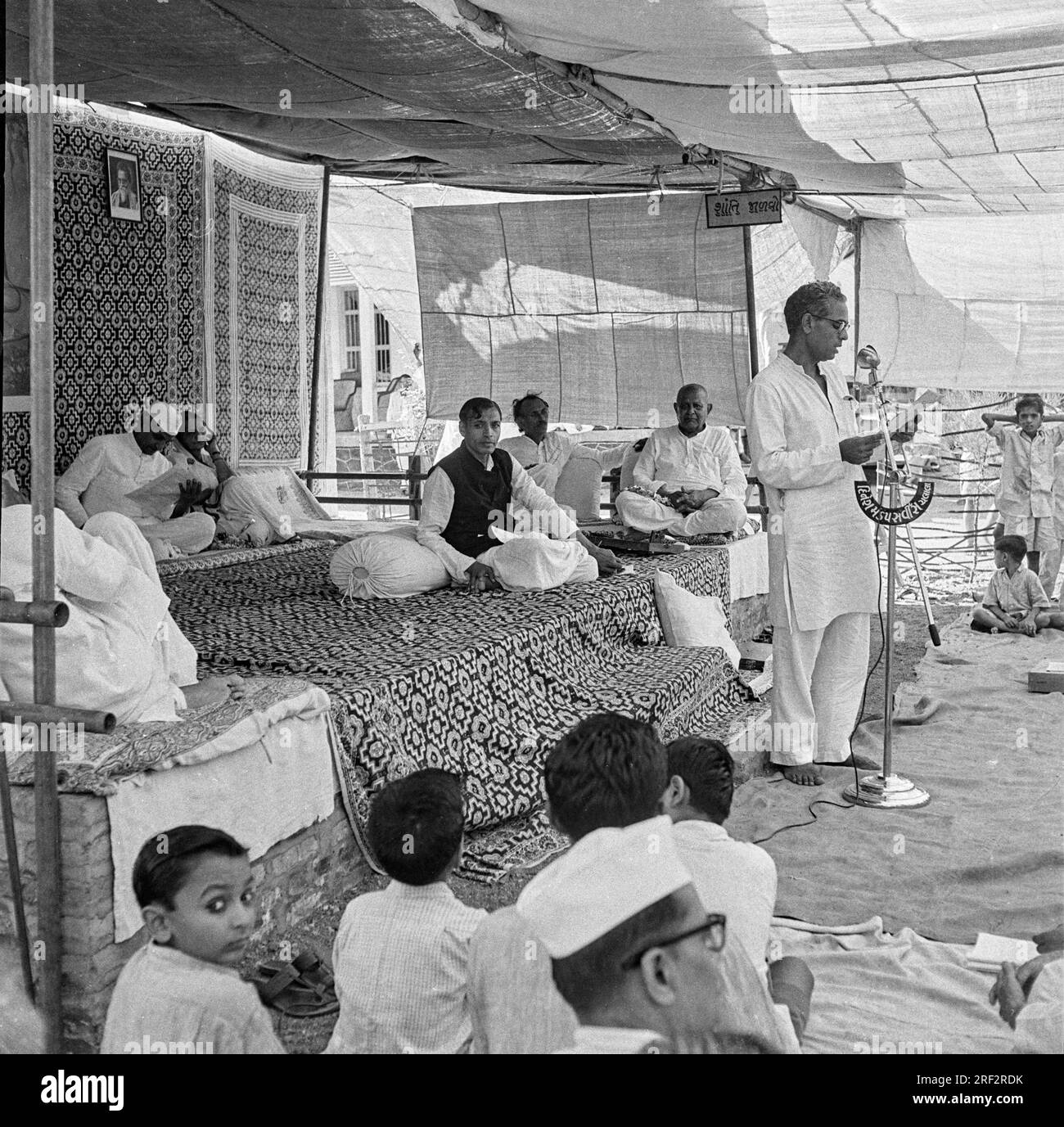 Altes schwarzweißes Bild aus dem Jahr 1900er, auf dem die Einwohner des indischen Dorfes Panchayat mit dem Mikrofon Dinesh Mandap Service Chalala Amreli Gujarat India 1940er zusammentreffen Stockfoto