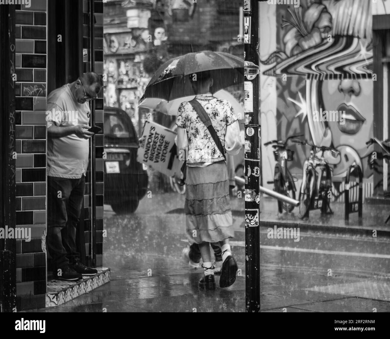 Die Leute werden im Regen in London extrem nass. Stockfoto