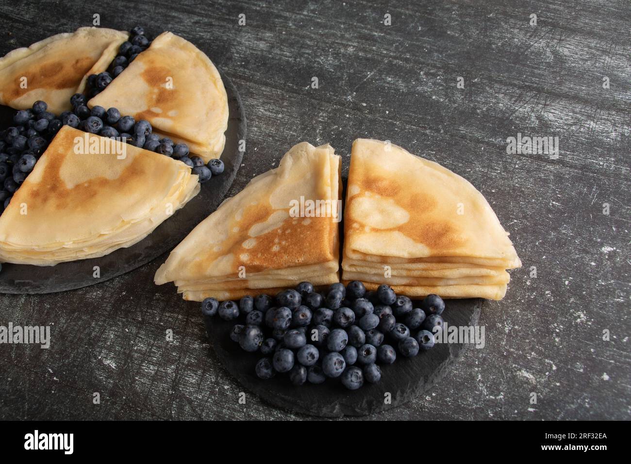 Foto von vielen dünnen Pfannkuchen auf einem Teller neben Heidelbeeren, Kohlenhydraten, Kalorien Stockfoto