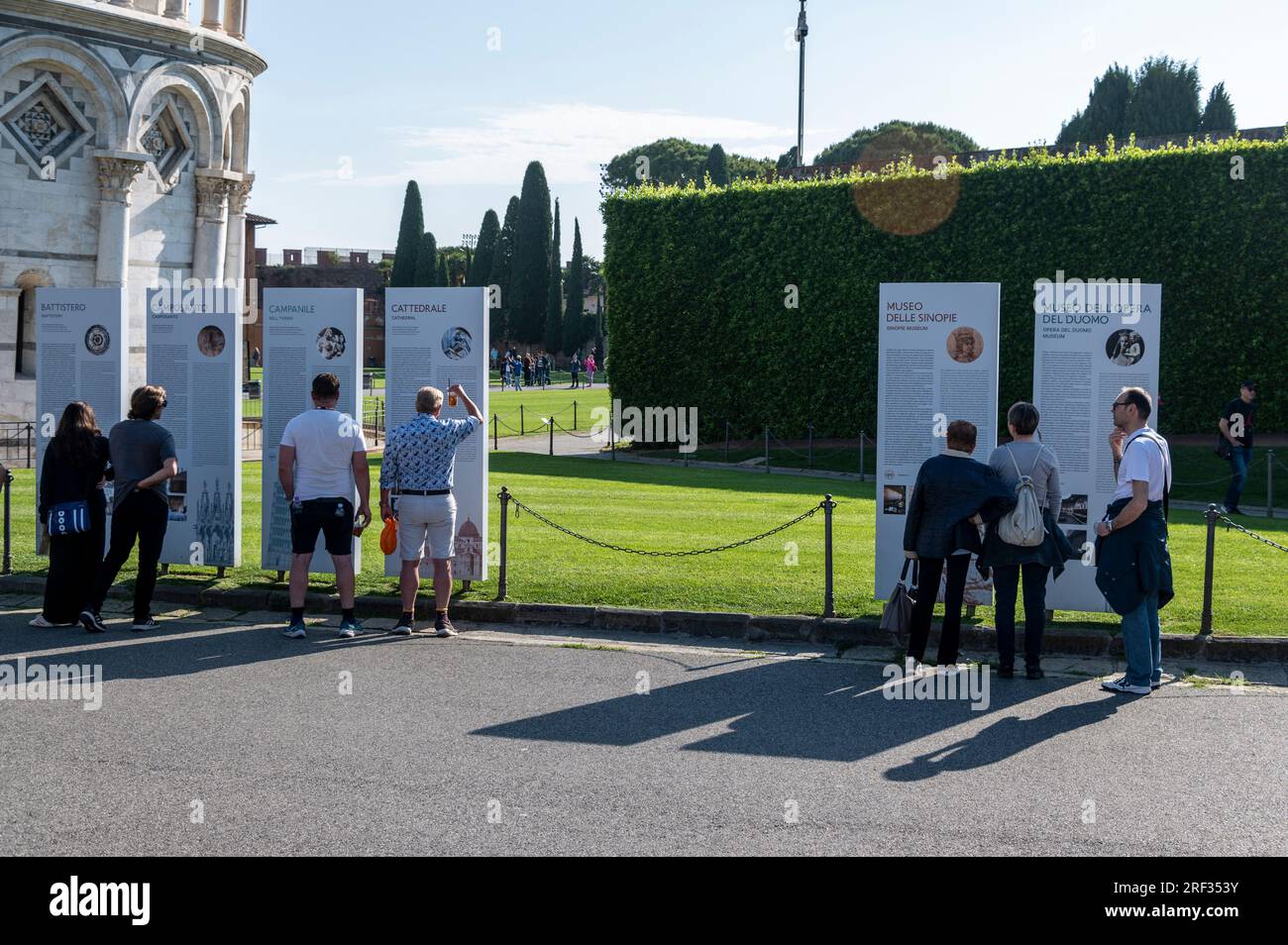 Touristen haben angehalten, um die Karte des Schiefen Turms auf der Plazza del Duomo in Pisa in der Toskana in Italien zu studieren Stockfoto