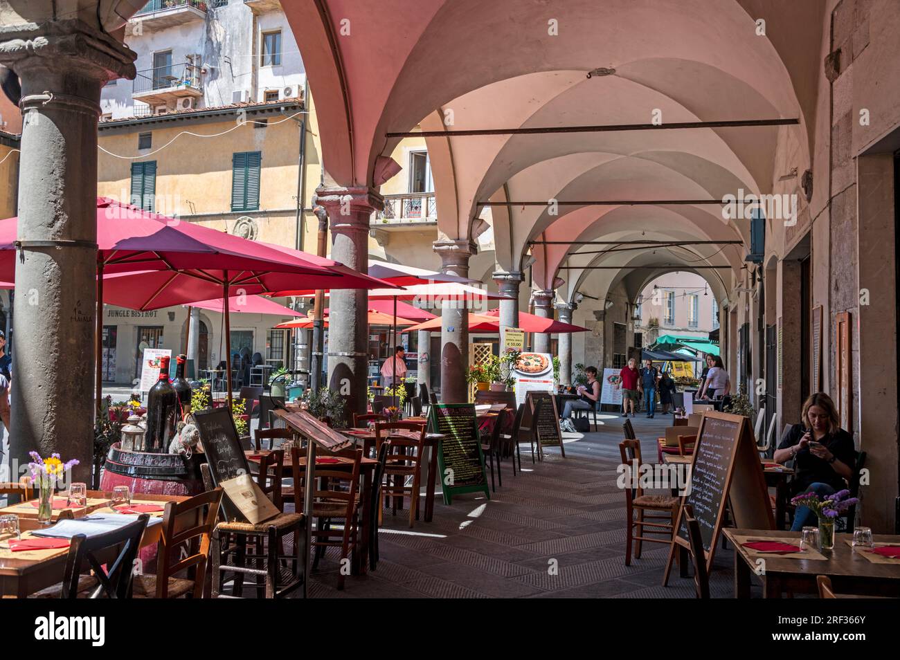 Unter dem Hauptbogen, der zu einem kleinen mittelalterlichen Platz führt, Piazza delle Vettovaglie mit umliegenden großen verdeckten Bögen, umgeben von Mitte 16. C. Stockfoto