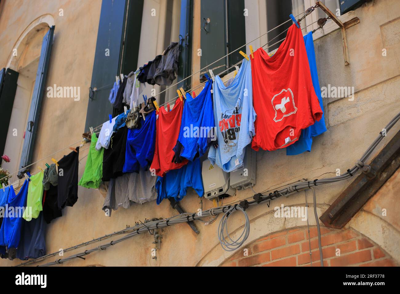 Kleidung hängt vor einem Fenster zum Trocknen in Venedig Stockfoto