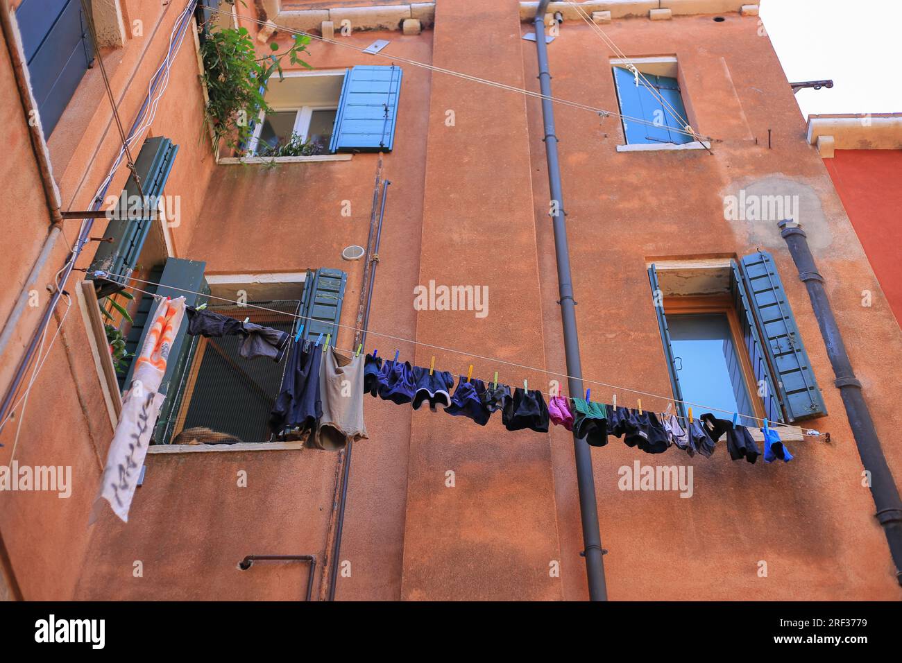 Kleidung hängt vor einem Fenster zum Trocknen in Venedig Stockfoto