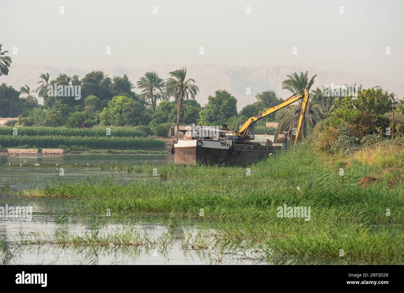 Panoramablick über den afrikanischen Fluss mit großem Baggerschiff am Flussufer Stockfoto