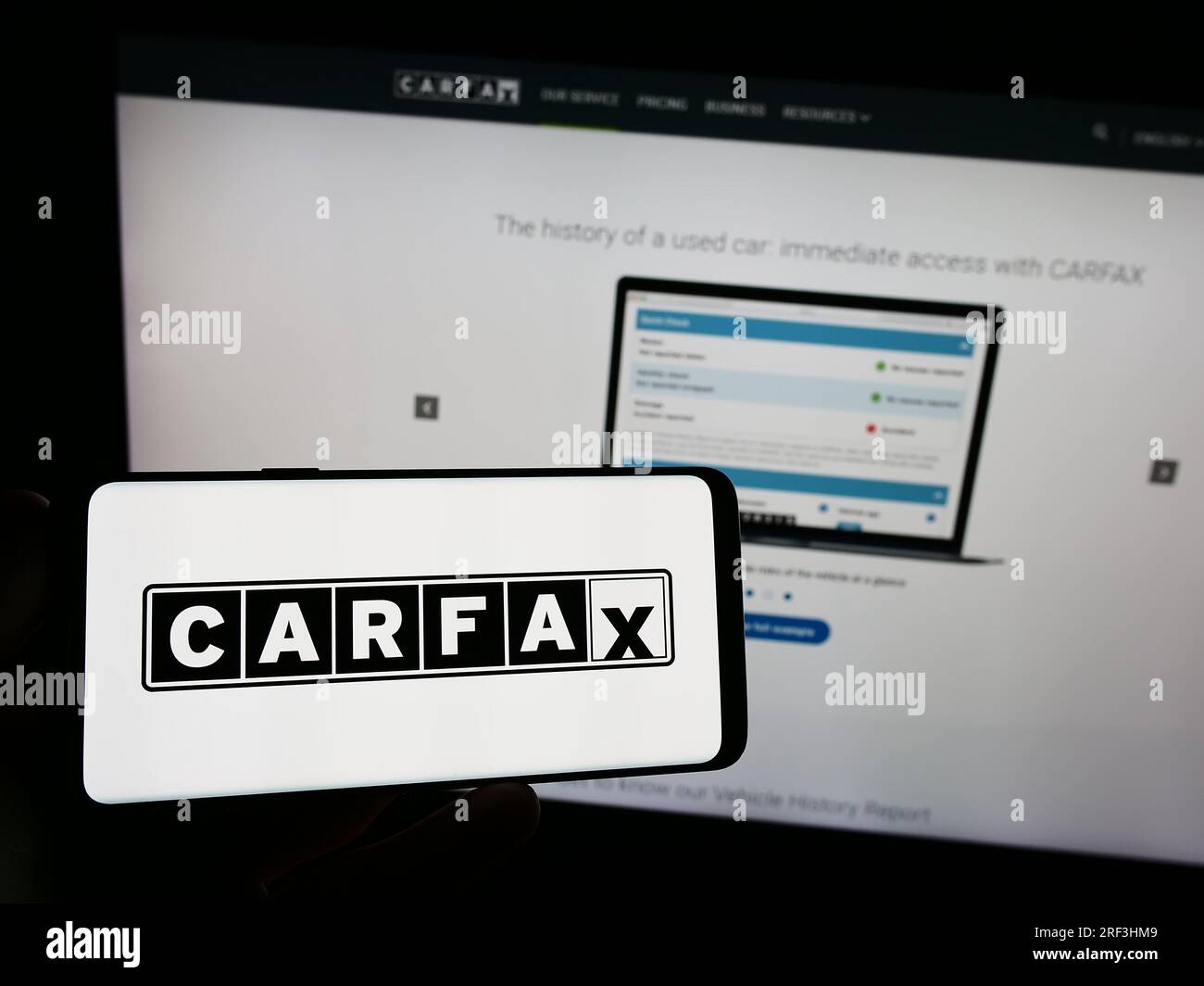 Person, die ein Smartphone mit dem Logo des US-amerikanischen Fahrzeugdatenunternehmens CARFAX Inc. Auf dem Bildschirm vor der Website hält. Konzentrieren Sie sich auf das Display des Telefons. Stockfoto